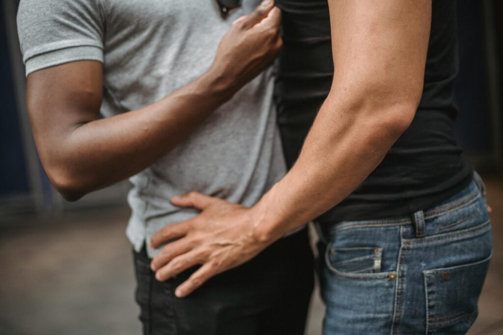 two men standing close to each other and touching
